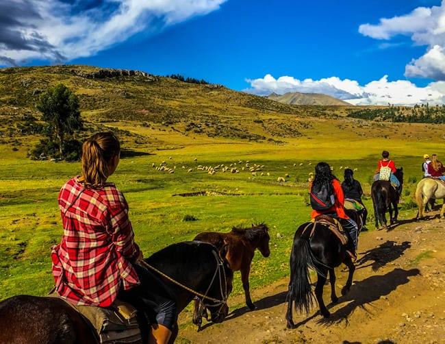 Tourists on horseback ride through Cusco | Ile Tours