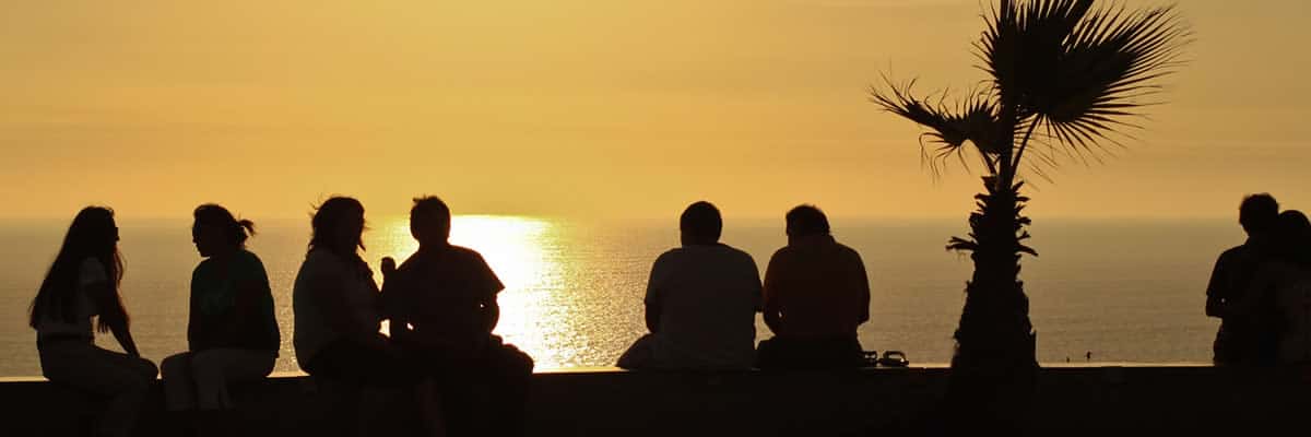 Tourists enjoying the sunset on the beach | Ile Tours