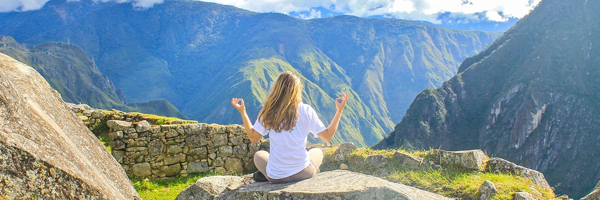 Tourist meditating in the sacred valley of Cusco | Ile Tours