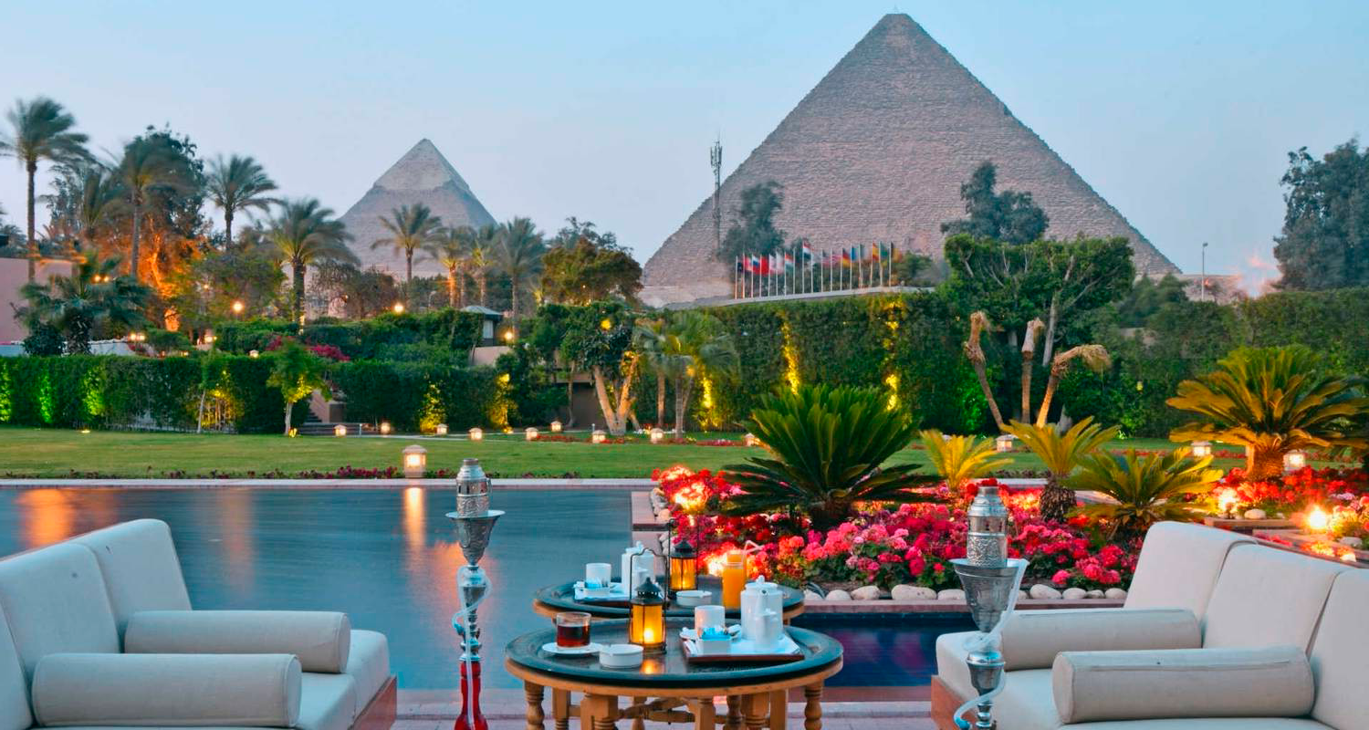 A stunning view of the ancient Egyptian pyramids and surrounding │ Ile Toursdesert landscape, seen from an opulent luxury suite.