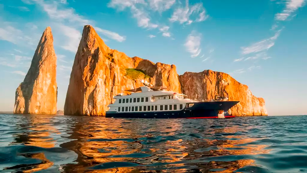 A luxurious yacht cruising through the pristine waters of the Galápagos Islands, offering an exclusive and unforgettable adventure. │ Ile Tours