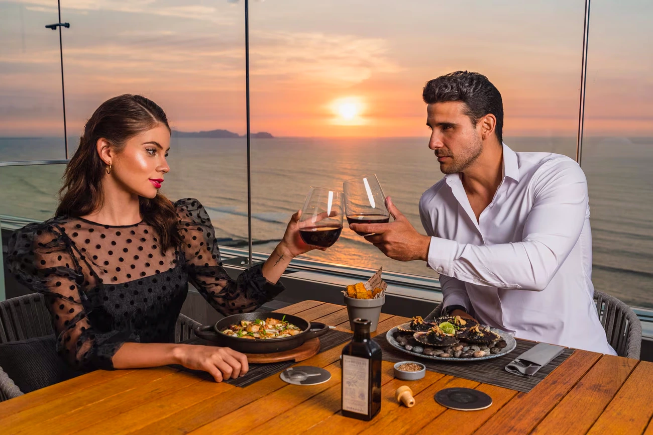 A sophisticated couple dining under the stars on an exclusive rooftop with a breathtaking view. | Ile Tours