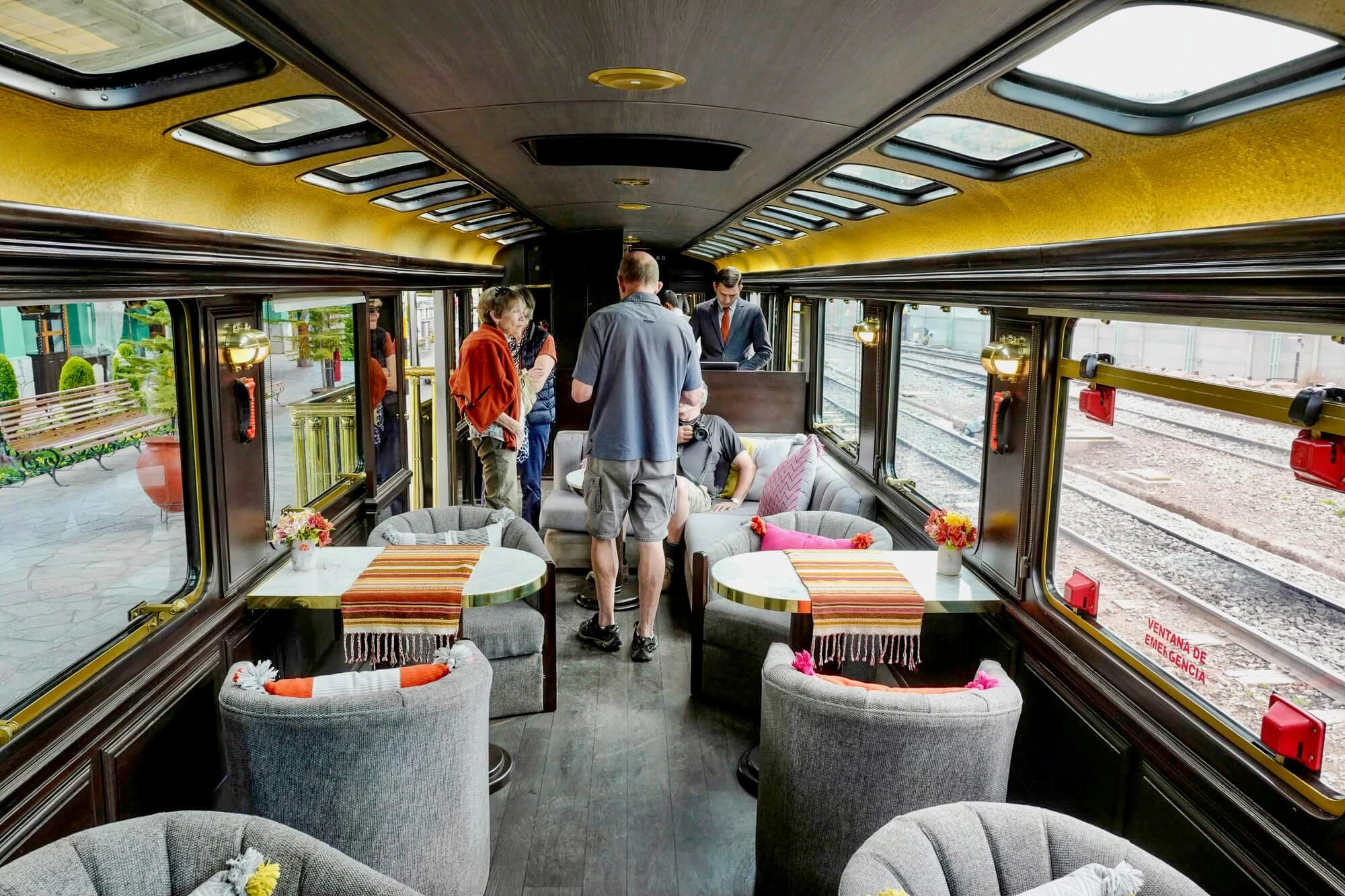 A chic couple sipping champagne aboard a lavish train traveling through the Peruvian Andes. | Ile Tours