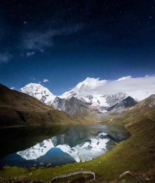 view of the sky beautifully mirrored on the surface of a lagoon in Cusco, Peru | Ile Tours